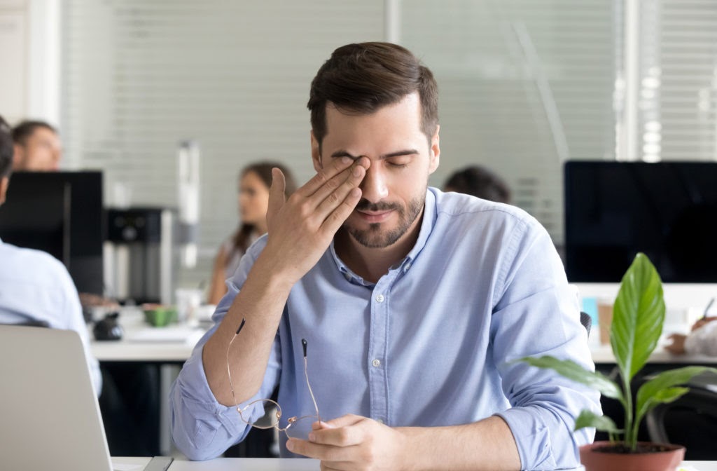 Young professional man frustrated due to dry eyes