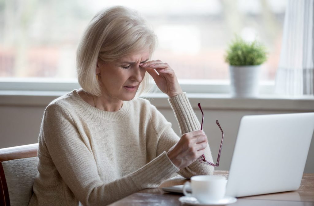 Older woman suffering from dry eye when using computer